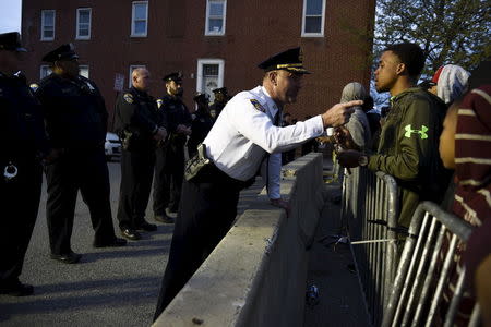 Captain Erik Pecha of the Baltimore Police Department chats with a young demonstrator in front of the Baltimore Police Department Western District station during a protest against the death in police custody of Freddie Gray in Baltimore April 23, 2015. REUTERS/Sait Serkan Gurbuz