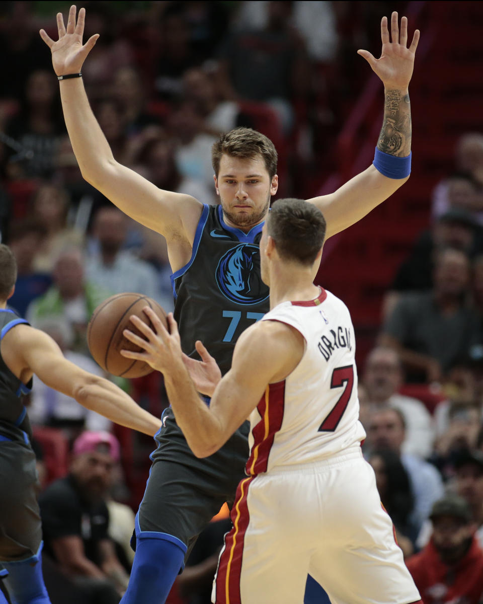 Dallas Mavericks forward Luka Doncic (77) defends against Miami Heat guard Goran Dragic (7) during the first half of an NBA basketball game, Thursday, March 28, 2019, in Miami. (AP Photo/Joel Auerbach)