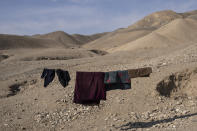 Clothes hang on a rope in Kamar Kalagh village outside Herat, Afghanistan, Friday, Nov. 26, 2021. In the small village, life is shriveling away as residents try to squeeze out what little water is left from their dwindling well. (AP Photo/Petros Giannakouris)