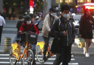 People wear face masks to protect against the spread of the coronavirus in Taipei, Taiwan, Tuesday, March 31, 2020. The new coronavirus causes mild or moderate symptoms for most people, but for some, especially older adults and people with existing health problems, it can cause more severe illness or death. (AP Photo/Chiang Ying-ying)