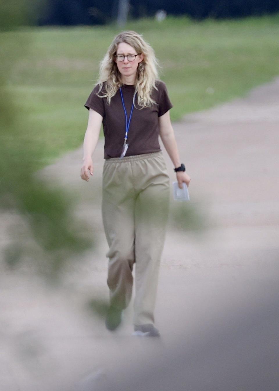 Elizabeth Holmes in a simple outfit in the grounds of a federal prison camp