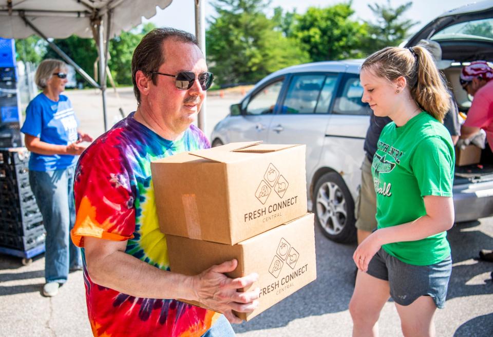 Julio Alonso, executive director of the Hoosier Hills Food Bank, carries boxes of food for distribution during the June 11, 2021, Fresh Friday event in Bloomington. Hoosier Hills Food Bank is currently seeking donations of food and funds to help with Thanksgiving food that will be handed out for the holiday.