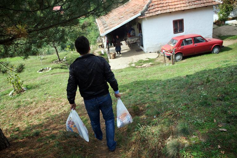 Postman Filip Filipovic brings groceries on October 7, 2013 to a family near Kursumlijska Banja, some 300 kms south of the capital Belgrade