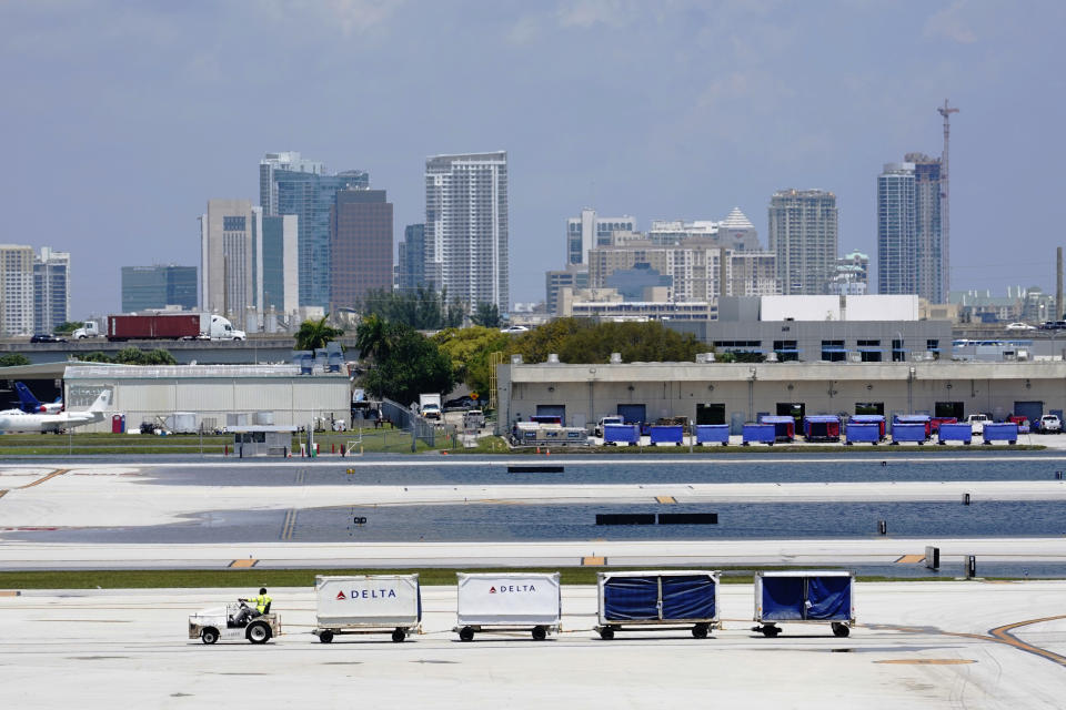 A Delta baggage train drives on the closed runway at Fort Lauderdale-Hollywood International Airport Friday, April 14, 2023, in Fort Lauderdale, Fla. The airport was able to open one of two runways after heavy rain flooded the runways. South Florida has begun draining streets and otherwise cleaning up after an unprecedented storm that dumped upward of 2 feet of rain in a matter of hours.(AP Photo/Marta Lavandier)