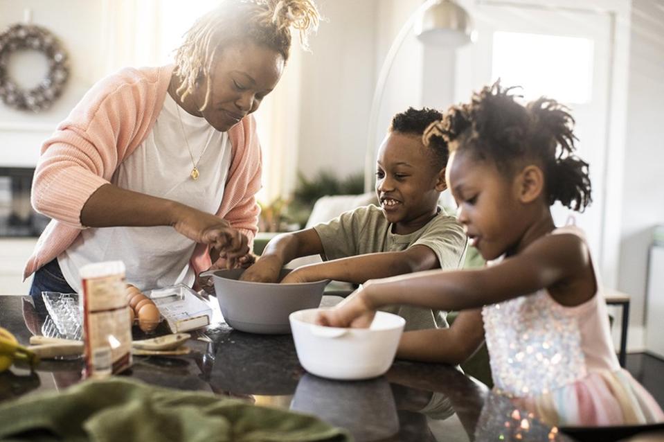 Los cambios en el cerebro de las madres pueden durar años. Una madre cocinando con su hijo e hija