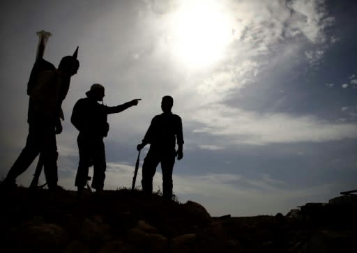 Syrian rebel-fighters with the National Liberation Front (NLF) stand on a hill overlooking regime-held areas in the northwestern countryside of Aleppo province on October 9, 2018