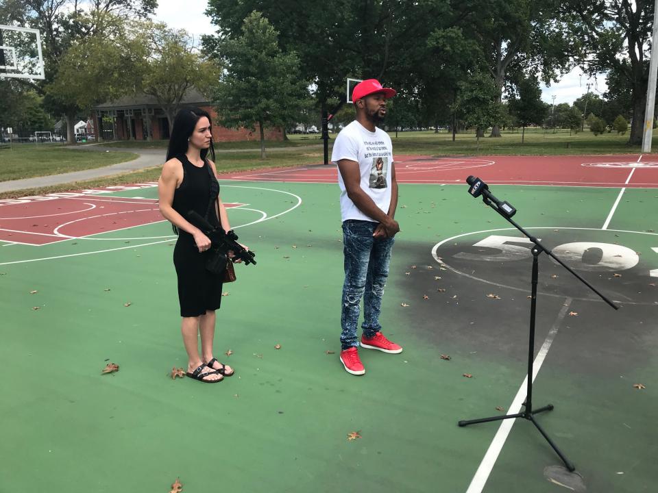 Kendrik Wilson, right, talks to media Sunday about his social media posts on the Breonna Taylor investigation while his friend Julia Robert holds a gun at Wyandotte Park south of Churchill Downs.