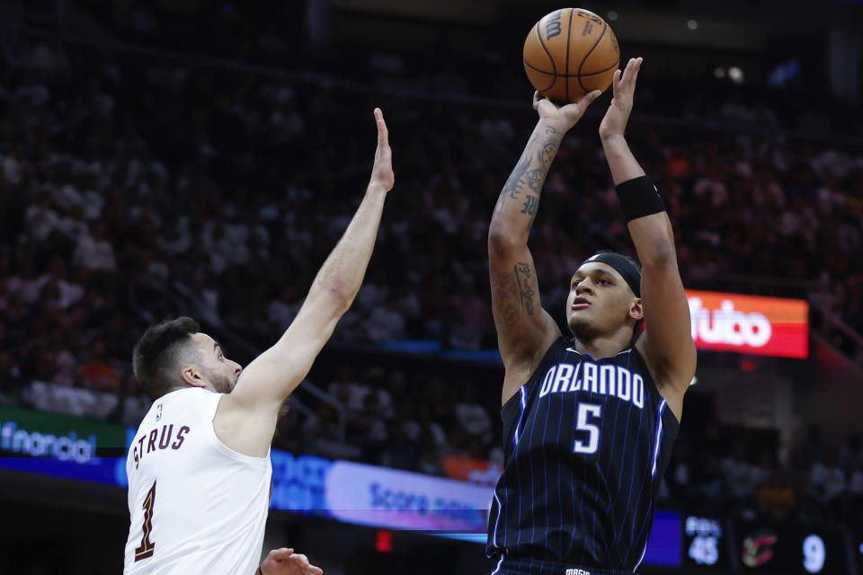 Orlando Magic forward Paolo Banchero (5) shoots against Cleveland Cavaliers guard Max Strus (1) during the second half of Game 2 of an NBA basketball first-round playoff series, Monday, April 22, 2024, in Cleveland. (AP Photo/Ron Schwane)