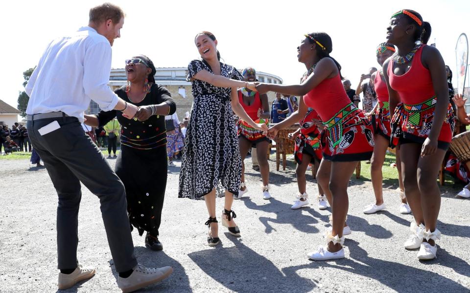 Prince Harry, Duke of Sussex and Meghan, Duchess of Sussex dance as they visit a Justice Desk initiative in Nyanga township, during their royal tour of South Africa on September 23, 2019 -  Chris Jackson/Getty