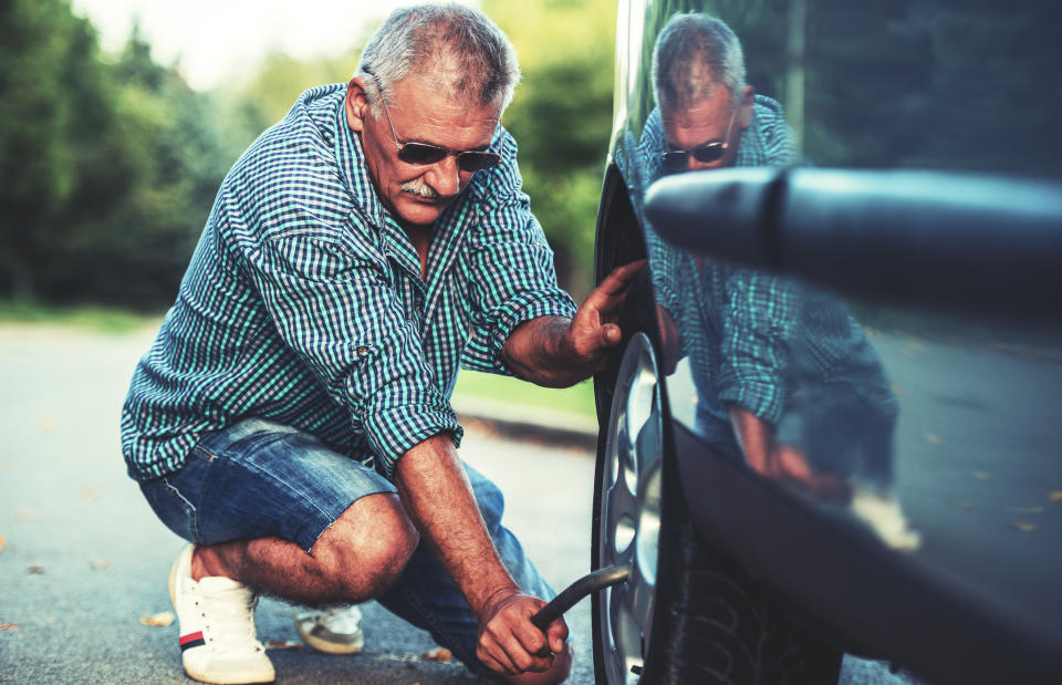 Old man changing a flat tire