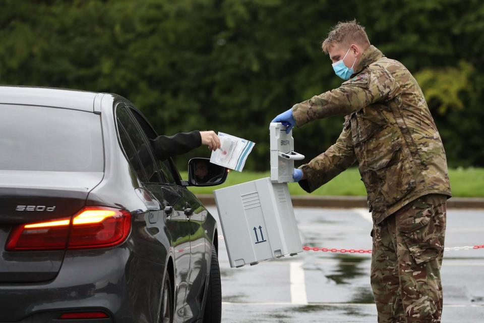 A coronavirus test is diposited into a box at a drive-in centre (PA)
