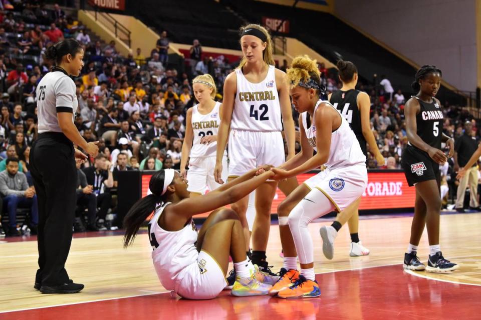 Jada Williams, right, helps up S’mya Nichols during the Girls Jr. NBA Global Championship on Aug. 11, 2019 at the ESPN Wide World of Sports Complex in Orlando.