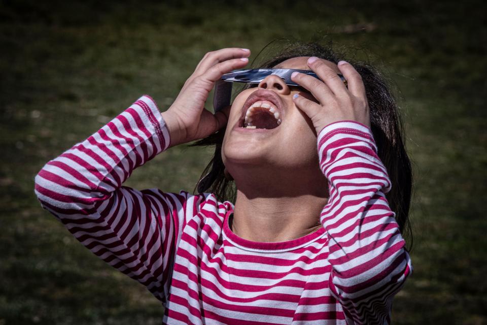 Coralie Halfman, 6, of Peekskill, watches the eclipse with her family at Riverfront Green Park in Peekskill, N.Y. April 8, 2024.