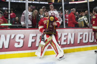 Denver goaltender Matt Davis (35) poses with the championship trophy, with his family behind him, after defeating Boston College in the championship game of the Frozen Four NCAA college hockey tournament Saturday, April 13, 2024, in St. Paul, Minn. Denver won 2-0 to win the national championship. (AP Photo/Abbie Parr)