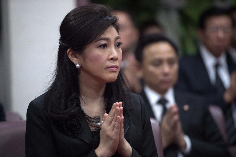 Ousted Thai prime minister Yingluck Shinawatra prays during a funeral ceremony inside a Buddhist temple in Bangkok on September 29, 2014