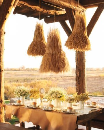 Indoors or out, a glowing tablescape like this one pulls all the rustic pieces together. It looks polished, but it’s actually quite resourceful: The harvest-theme chandeliers are wheat-covered wire baskets, and the vases holding clouds of pretty wildflowers are recycled metal cans spray-painted a glossy white. For an instant, on-point tablecloth, lay out a length of raw-edged leather.  <a href="http://www.marthastewartweddings.com/340624/wheat-chandelier?center=285523&gallery=231286&slide=340624" target="_blank">Get the How-To</a>