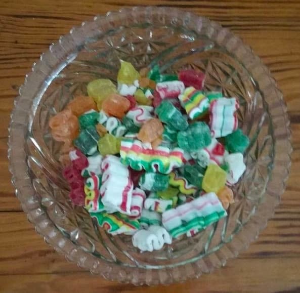 Glass dish with stuck-together multicolored mint and other candies