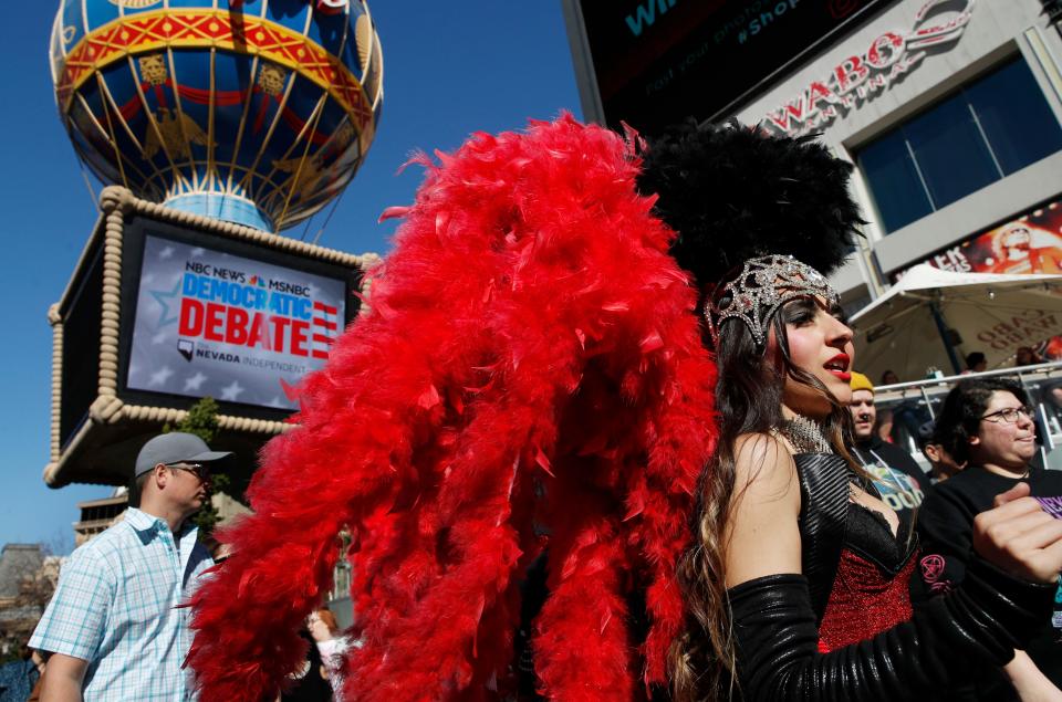 People dressed as showgirls walk near the Paris Las Vegas hotel casino on Feb. 19, 2020, site of a Democratic presidential debate, in Las Vegas. If Nevada has one job in the Democratic primary, it's to offer something different. And in many ways it has delivered. As the presidential race turned to the state this week, gone was the earnestness of Iowa and tradition of New Hampshire and in its place was racial diversity, a new unpredictability and the muscle of urban, union politics.