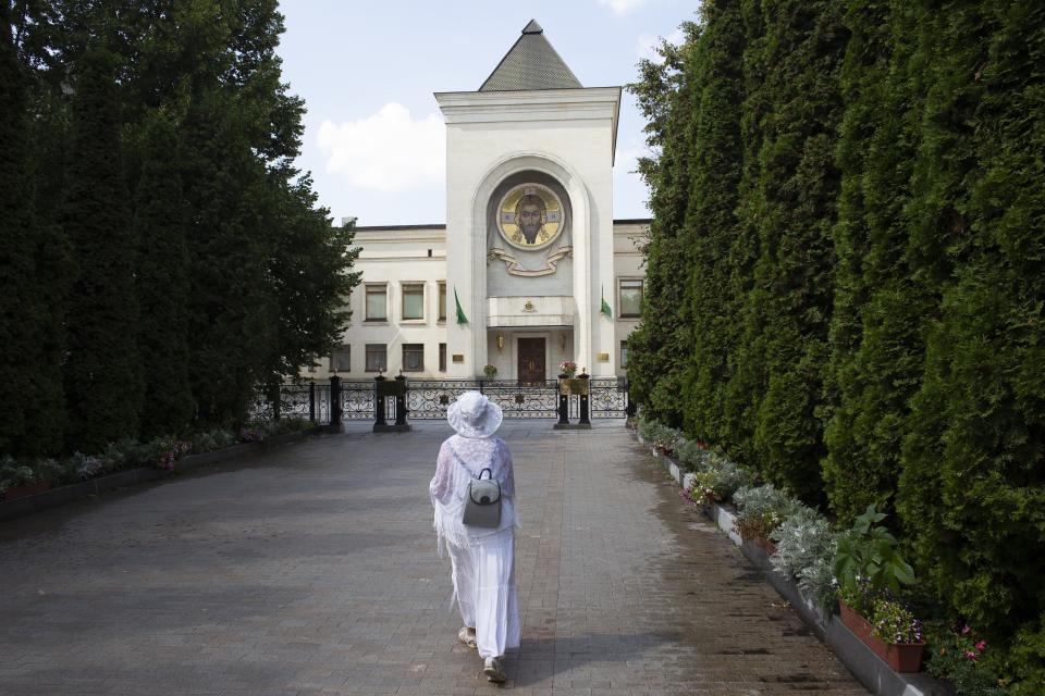 FILE - In this Friday, Aug. 3, 2018 file photo, a woman walks toward the Russian Orthodox Church headquarters in the St. Daniel Monastery in Moscow, Russia. The Kremlin is scrambling to help Moscow’s Patriarch Kirill retain his traditional role as the head of the Ukrainian Orthodox Church and “the more they know, the better it is for them,” says Vasilios Makrides, a specialist in Orthodox Christianity at the University of Erfurt in Germany. (AP Photo/Pavel Golovkin, File)