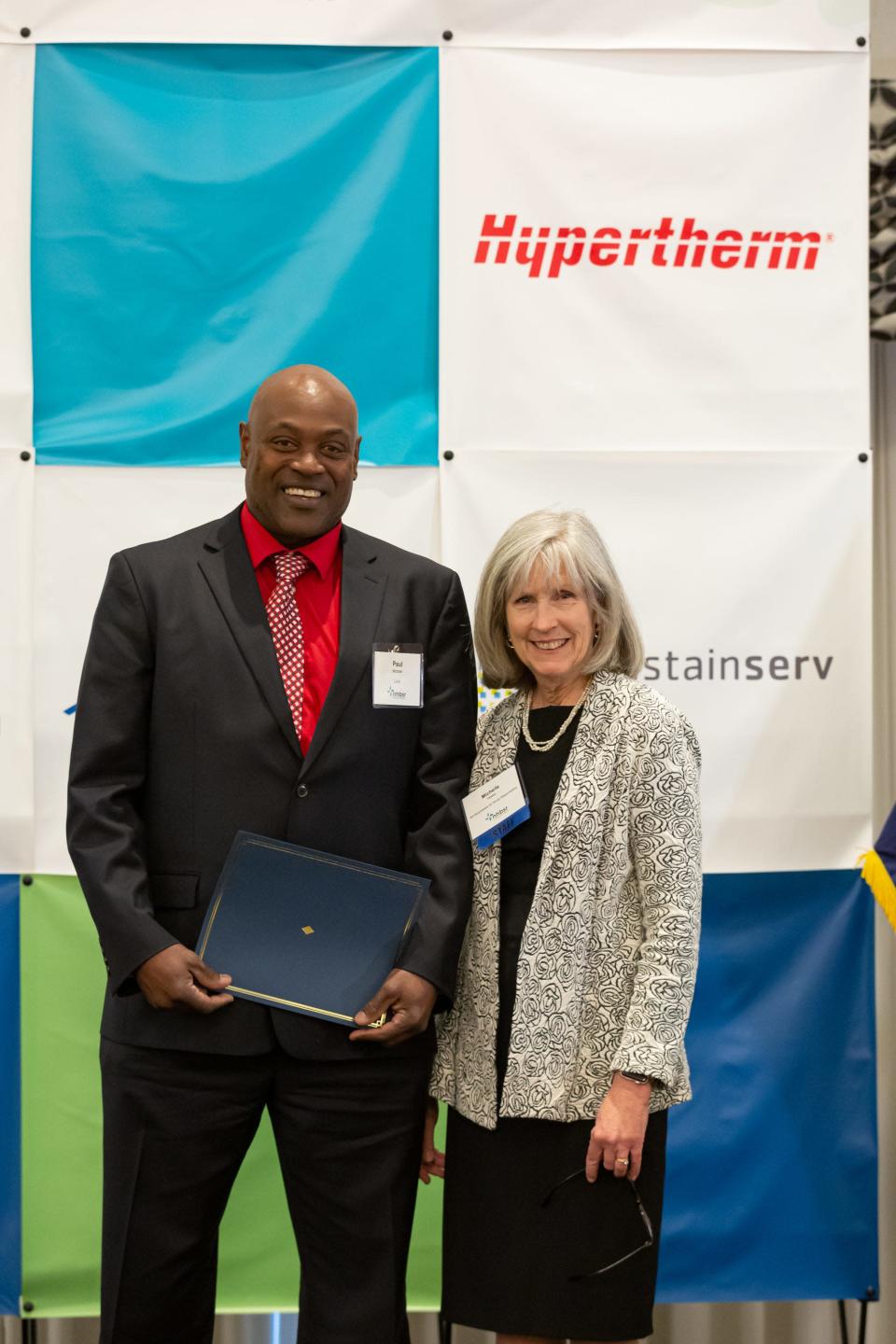 Paul Michael receives the Changemaker Award from Michelle Veasey, NHBSR executive director, at Wednesday&#x002019;s &#x00201c;Uniting on Purpose&#x00201d; spring conference.