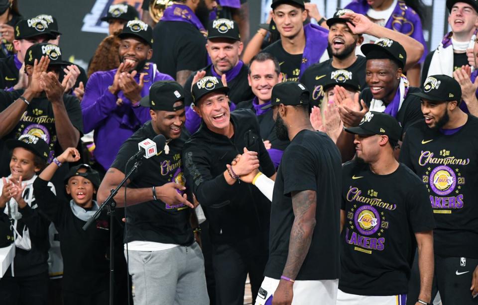 Lakers general manager Rob Pelinka clasps hands with star forward LeBron James after winning the 2020 NBA title.