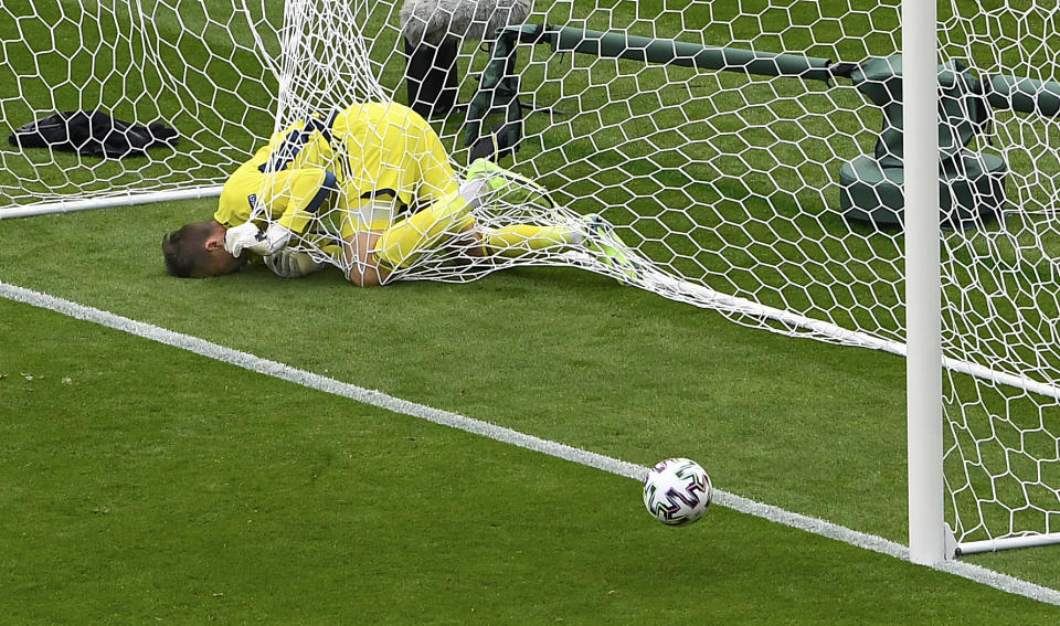 Scotland's goalkeeper David Marshall is caught in the goal's net after he failed to save a long distance shot by Czech Republic's Patrik Schick during the Euro 2020 soccer championship group D match between Scotland and Czech Republic at Hampden Park stadium in Glasgow, Monday, June 14, 2021. (AP Photo/Andy Buchanan, Pool)