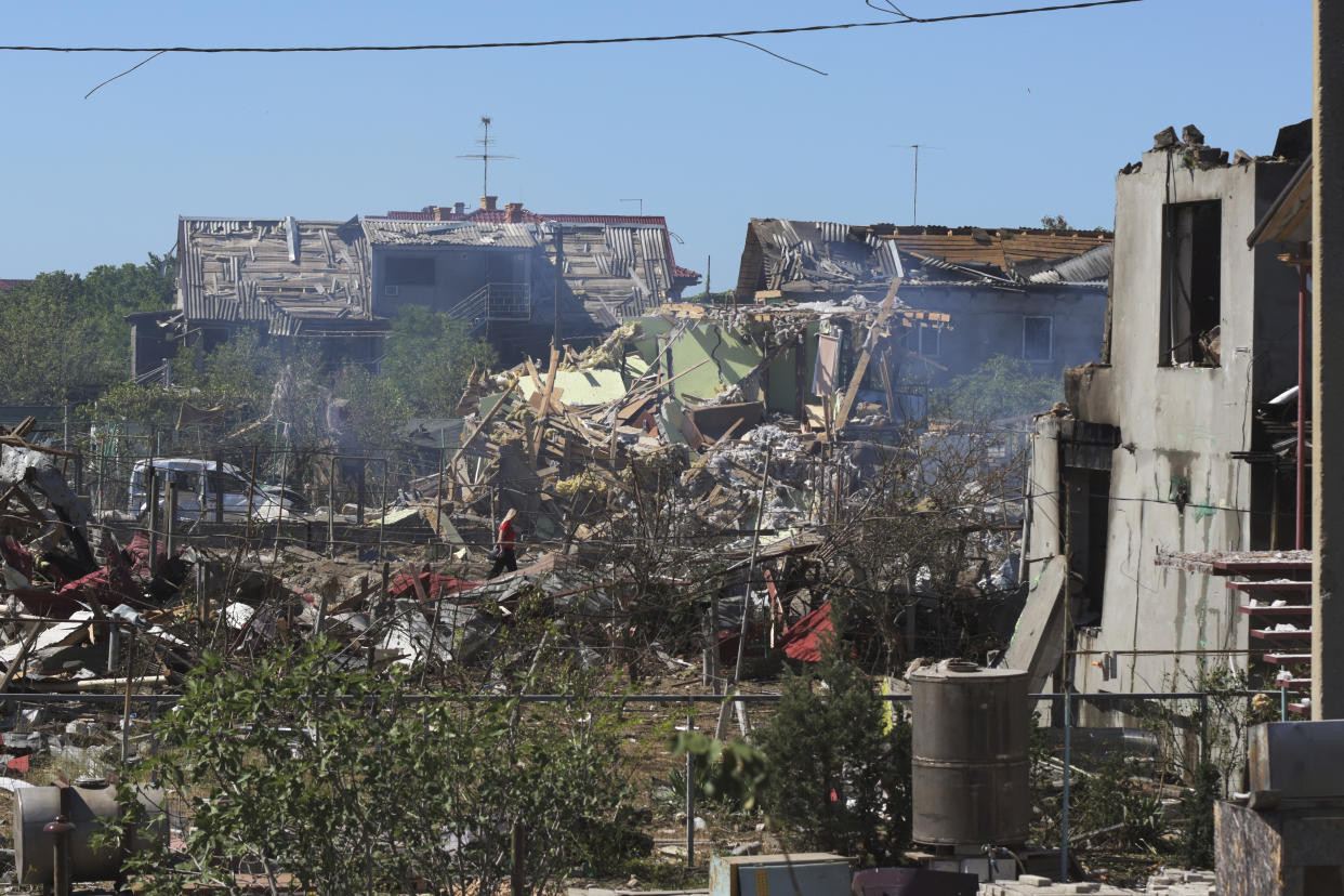 A woman walks among apartment buildings destroyed by Russian shelling on the outskirts of Odesa, Ukraine, Tuesday, July 26, 2022. (AP Photo/Michael Shtekel)