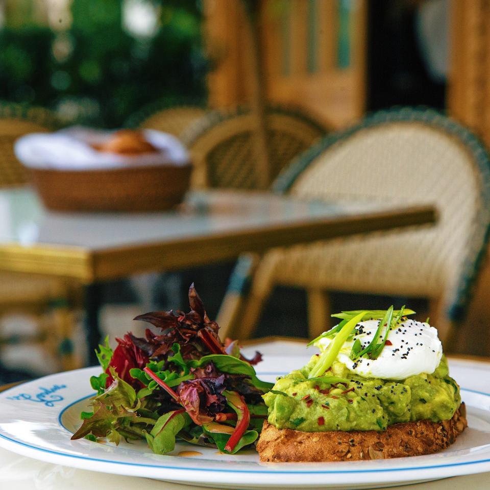 Avocado toast, topped with a poached egg, chopped scallions, poppy seeds and red pepper flakes and served with a petite salad, is offered on La Goulue's new lunch menu.