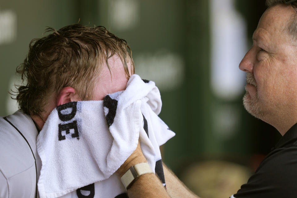 San Francisco Giants trainer Dave Groeschner applies a cold wet towel to the face of starting pitcher Logan Webb during the fourth inning of a baseball game against the Chicago Cubs Monday, Sept. 4, 2023, in Chicago. (AP Photo/Charles Rex Arbogast)