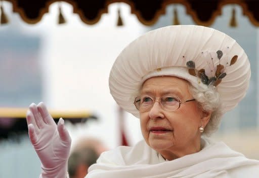 Britain's Queen Elizabeth II waves from the royal barge "Spirit of Chartwell" as it sails past the Houses of Parliament during the Thames during the diamond jubilee river pageant to celebrate her 60 years on the throne