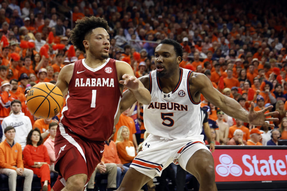 Alabama guard Mark Sears (1) drives the baseline around Auburn forward Chris Moore (5) during the first half of an NCAA college basketball game, Wednesday, Feb. 7, 2024, in Auburn, Ala. (AP Photo/Butch Dill)