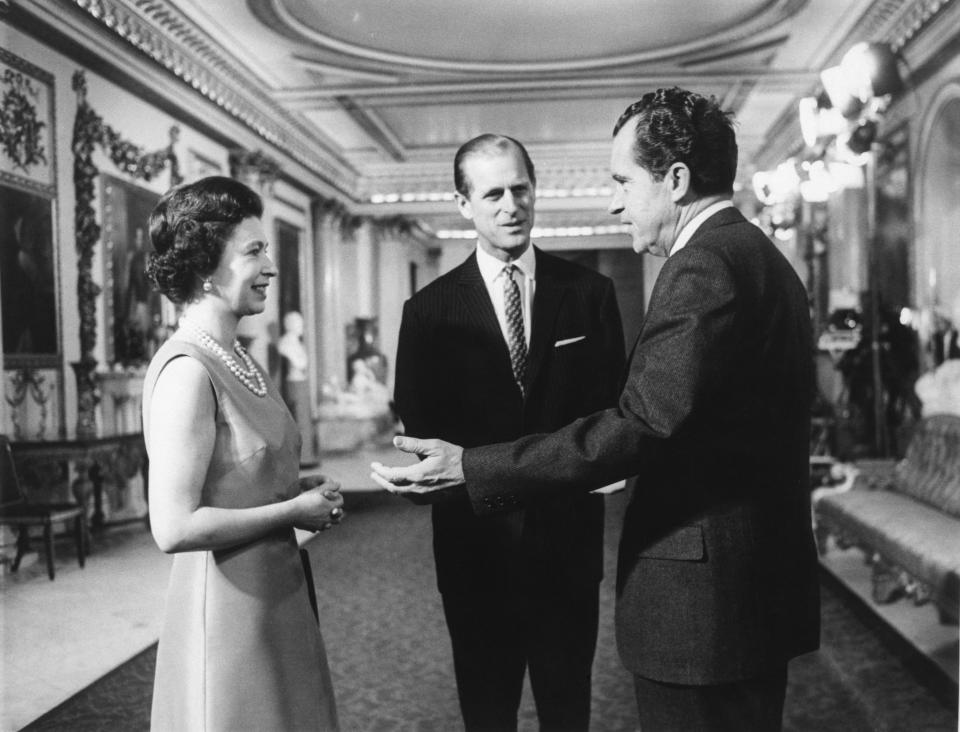 President Nixon speaks with Queen Elizabeth II and Prince Philip at Buckingham Palace.