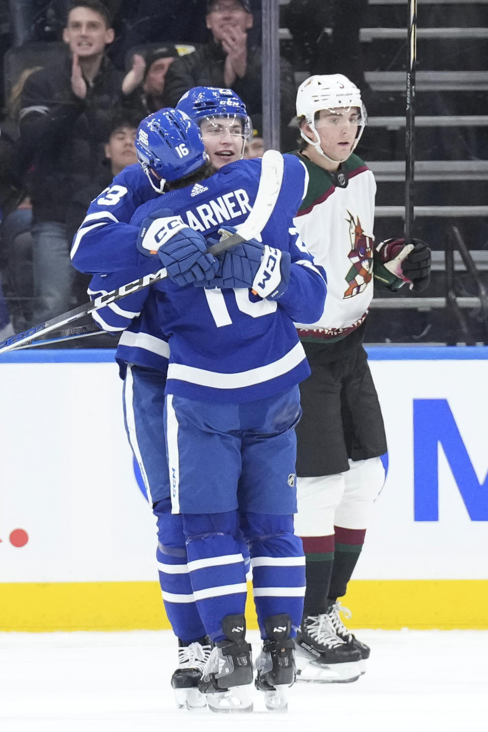 Toronto Maple Leafs' Matthew Knies, center, celebrates with Mitchell Marner (16) after scoring against the Arizona Coyotes during first-period NHL hockey game action in Toronto, Thursday, Feb. 29, 2024. (Chris Young/The Canadian Press via AP)