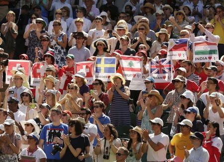 Fans of Roger Federer of Switzerland hold up flags during his match against Damir Dzumhur of Bosnia and Herzegovina at the Wimbledon Tennis Championships in London, June 30, 2015. REUTERS/Henry Browne