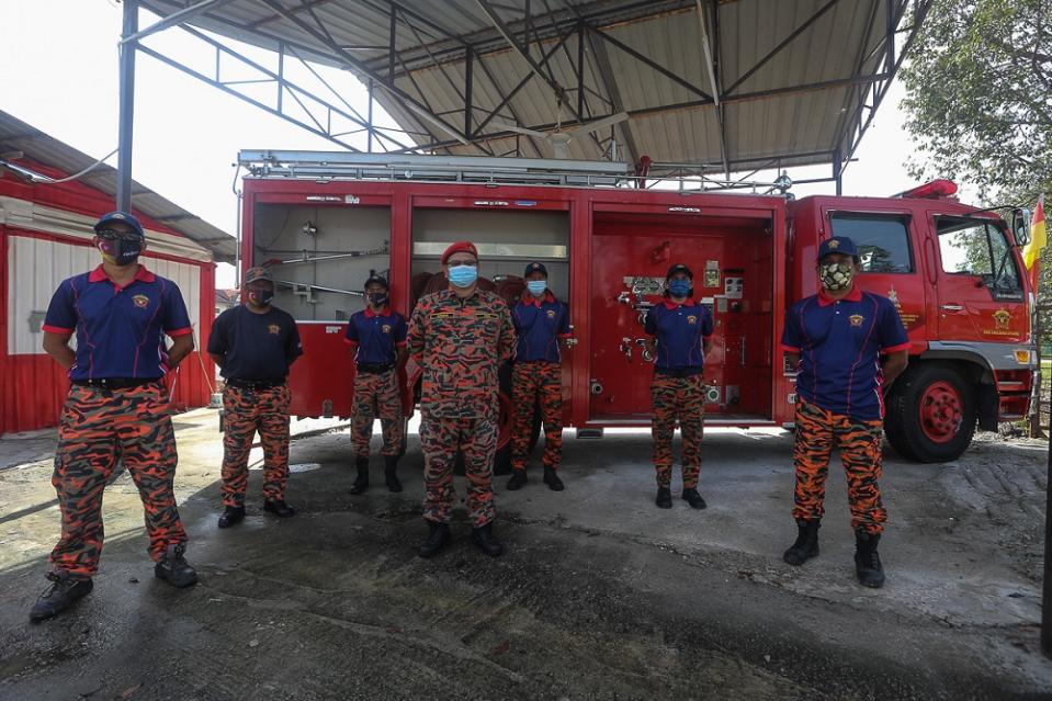 Members of the Pasukan Bomba Sukarela Saujana Utama (PBSSU) pose for a photograph in front of their station. — Picture by Mohd Yusof Mat Isa