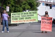 <p>“Ministerio de Salud, por favor, incluya a las trabajadoras sexuales como grupo prioritario de vacunación” y “Trabajadoras sexuales son grupo prioritario” rezan las pancartas que sujetan estas dos mujeres. (Foto: Douglas Magno / AFP / Getty Images).</p> 