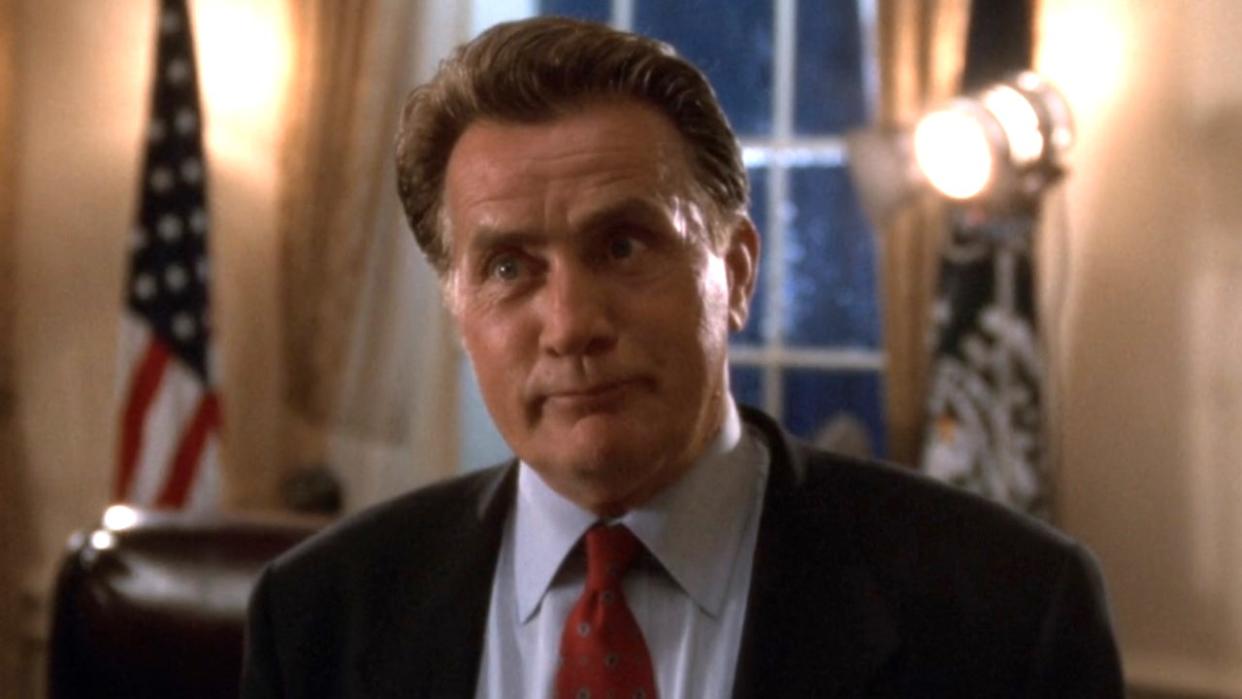  President Bartlet smiles confidently in the Oval Office in The West Wing episode "A Proportional Response.". 