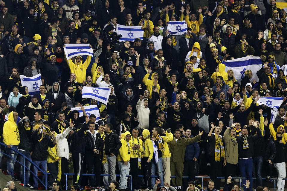 Supporters of Beitar Jerusalem cheer for their team during a soccer match against Maccabi Umm el-Fahm at Teddy Stadium in Jerusalem January 29, 2013. Hundreds of police officers and stewards secured the Israeli State Cup match on Tuesday in which Premier League Beitar Jerusalem, supported by a group of vehement anti-Arab fans, host Arab side Maccabi Umm el-Fahm. A racist element among Beitar fans caused uproar in the Jewish state on Saturday when they held up banners during a Premier League match to protest at owner Arkady Gaydamak's planned recruitment of two Chechen Muslim players. REUTERS/Nir Elias (JERUSALEM - Tags: SPORT SOCCER SOCIETY)