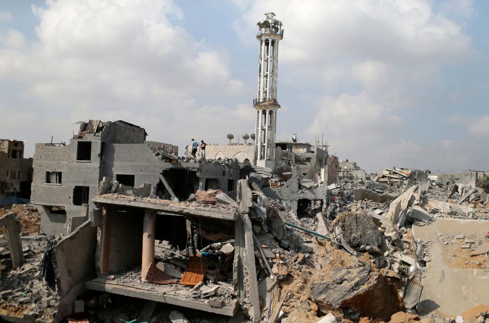Palestinians stand atop the remains of their house after returning to it in the Shejaia neighborhood, which witnesses said was heavily hit by Israeli shelling and air strikes during an Israeli offensive, in the east of Gaza City August 5, 2014