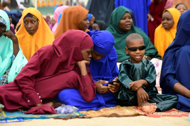 Unas jóvenes miran un teléfono móvil durante la oración del Eid al Fitr en Maiduguri, Nigeria, el 10 de abril de 2024 (Audu Marte)