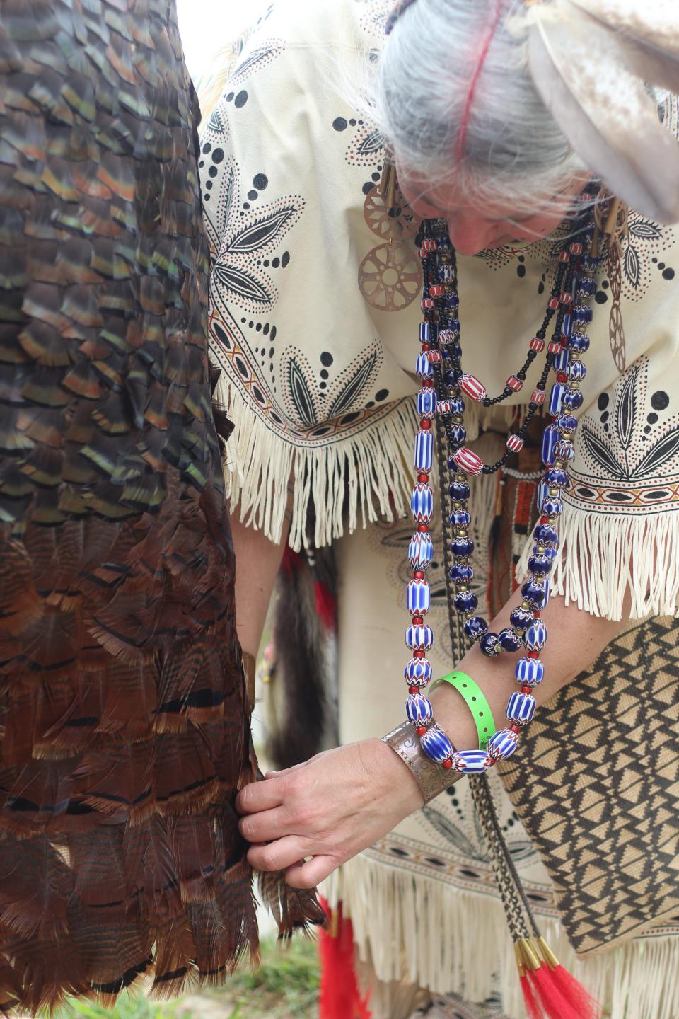 Julia Marden, a member of the Wampanoag Tribe of Gay Head (Aquinnah), smooths out the turkey feather mantle that she revealed during the Aquinnah Wampanoag Powwow Sunday.