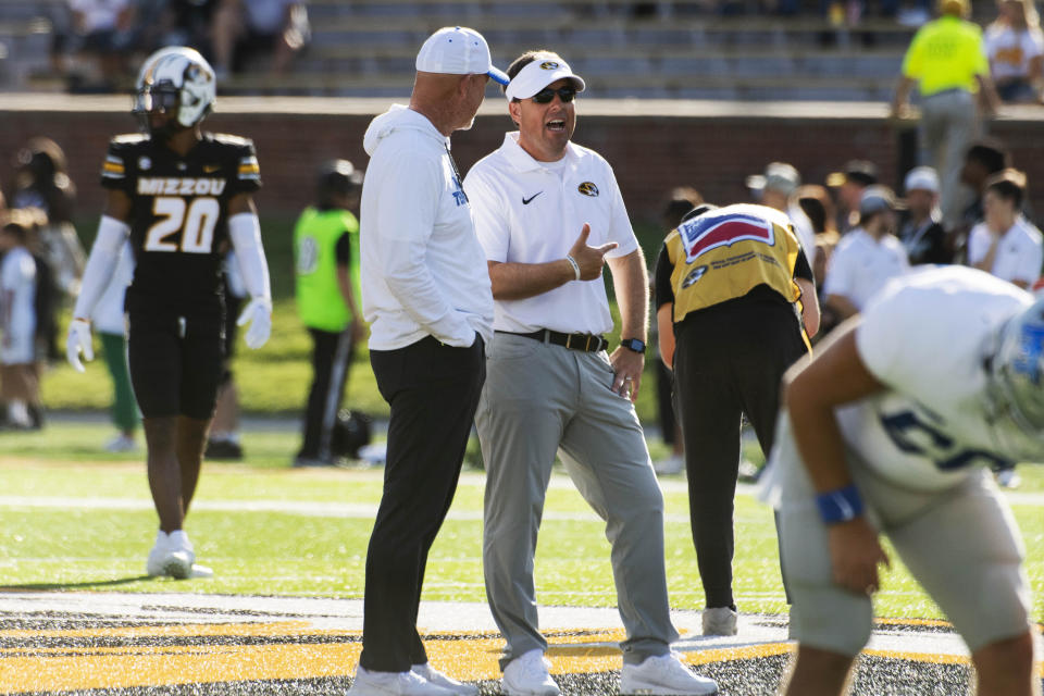 Missouri head coach Eliah Drinkwitz, center right, and Middle Tennessee head coach Rick Stockstill, left, talk during warmup before the start of an NCAA college football game Saturday, Sept. 9, 2023, in Columbia, Mo. (AP Photo/L.G. Patterson)