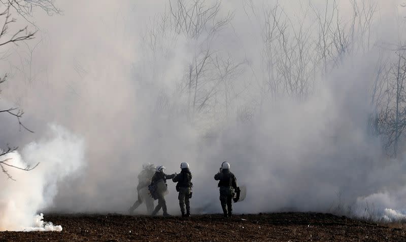 FILE PHOTO: Greek riot police officers stand amid clouds of tear gas near Turkey's Pazarkule border crossing, in Kastanies