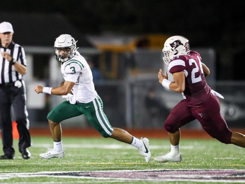 Caravel defensive end Ira Yates (right) forces Archmere quarterback Miles Kempski to scramble in the Buccaneers’ 28-2 win over the Auks, Friday, Sept. 29, 2023 at Bob Peoples Stadium.