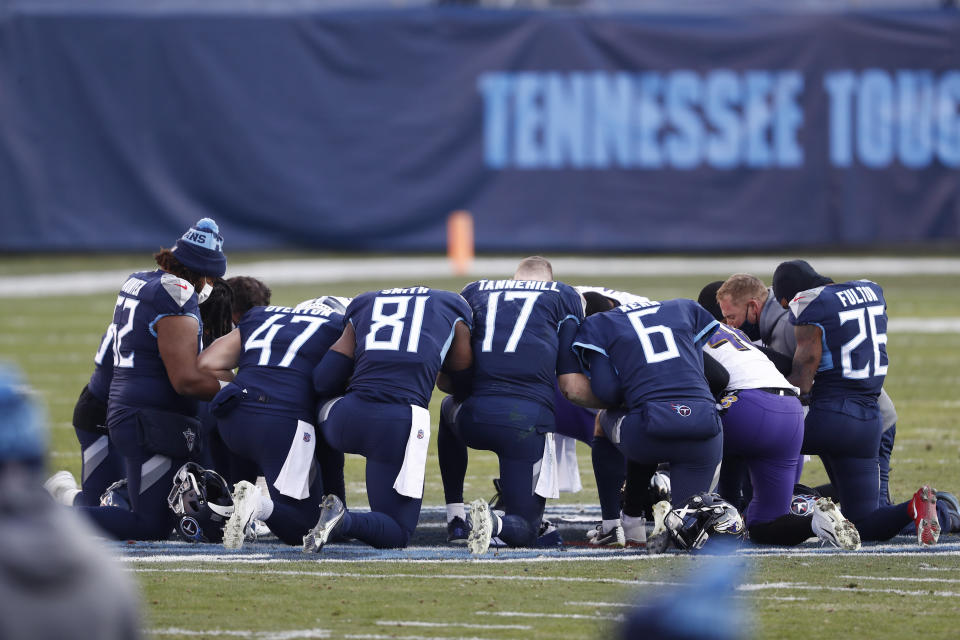 Tennessee Titans players pray on the field after losing to the Baltimore Ravens in an NFL wild-card playoff football game Sunday, Jan. 10, 2021, in Nashville, Tenn. The Ravens won 20-13. (AP Photo/Wade Payne)
