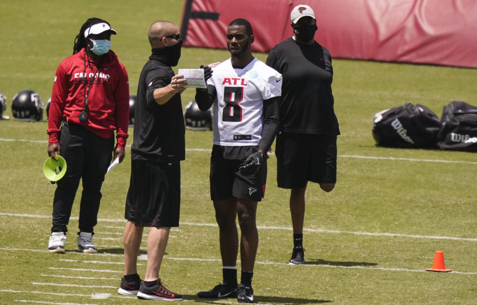 Atlanta Falcons' Kyle Pitts, center, talks with a coach during an NFL football rookie minicamp on Friday, May 14, 2021, in Flowery Branch, Ga. (AP Photo/Brynn Anderson)