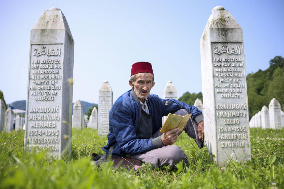 A Bosnian muslim man prays next to the grave of his relative, victim of the Srebrenica genocide, in Memorial Centre in Potocari, Bosnia, Tuesday, July 11, 2023. Thousands converge on the eastern Bosnian town of Srebrenica to commemorate the 28th anniversary on Monday of Europe's only acknowledged genocide since World War II. (AP Photo/Armin Durgut)