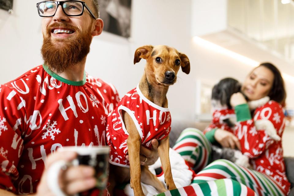 family and their dogs wearing matching Christmas pajamas