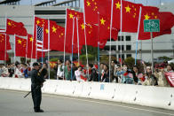 With American and Chinese flags flying, people watch as the motorcade carrying President Joe Biden drives past Tuesday, Nov. 14, 2023, in San Francisco. (AP Photo/Evan Vucci)