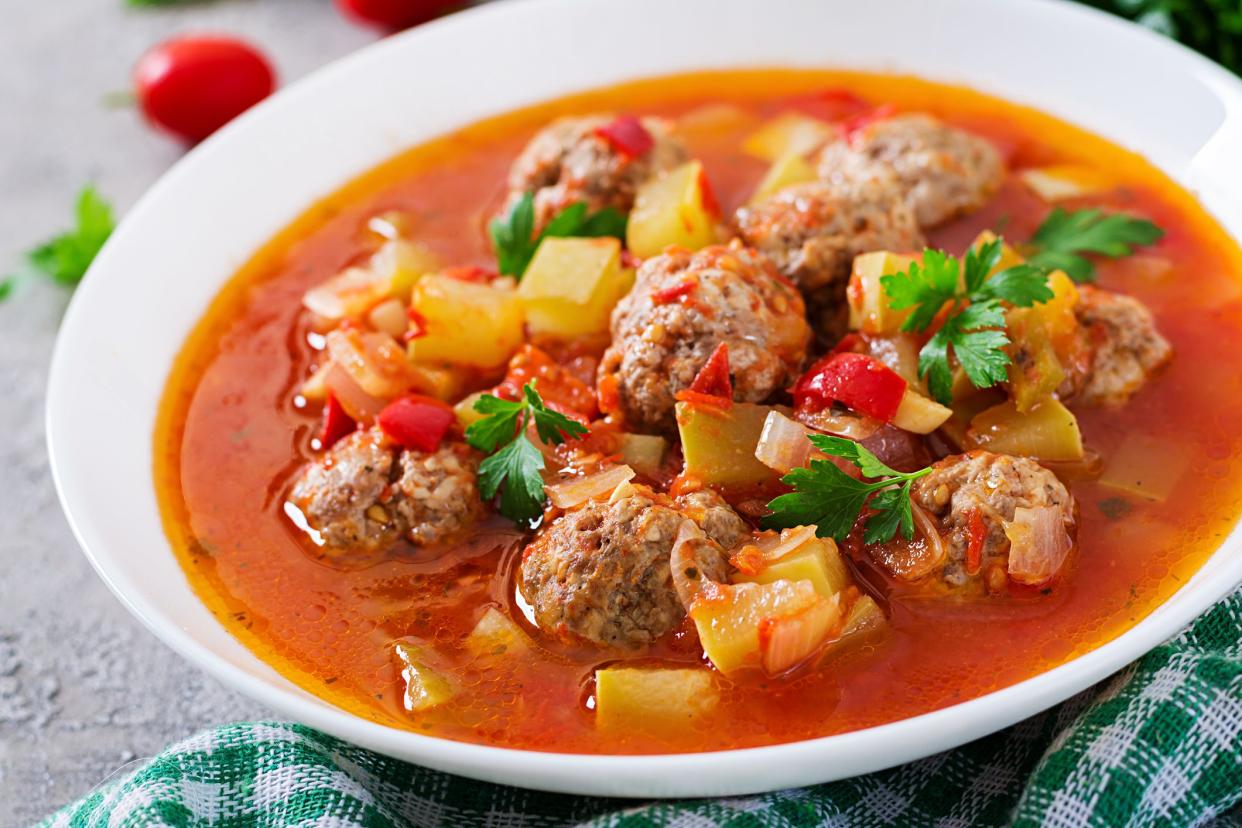 Hot stew tomato soup with meatballs and vegetables closeup in a bowl on the table. Albondigas soup, spanish and mexican food.